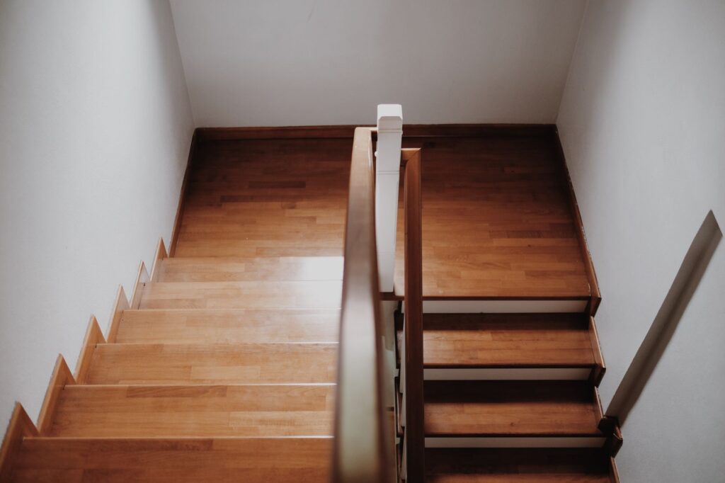 Gerade Holztreppe mit Handlauf in einem Wohnhaus, von oben gesehen